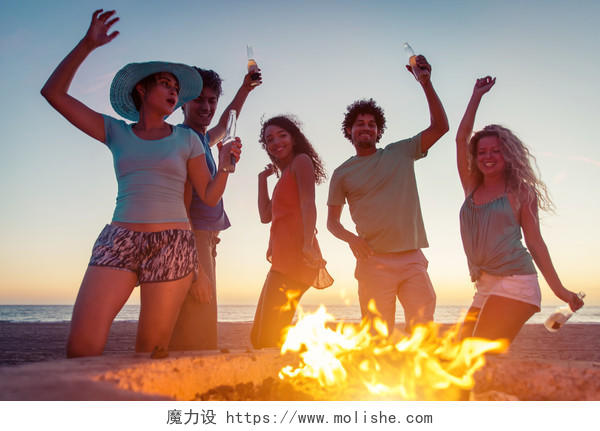 一群朋友在沙滩上举行篝火晚会